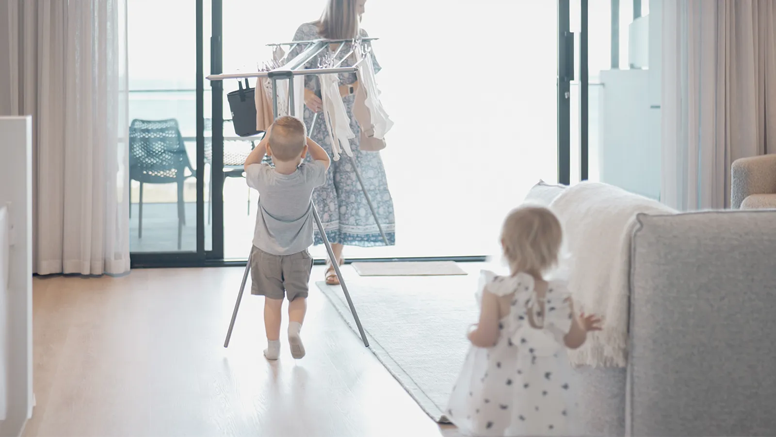 A mum carrying a clothesline with her son